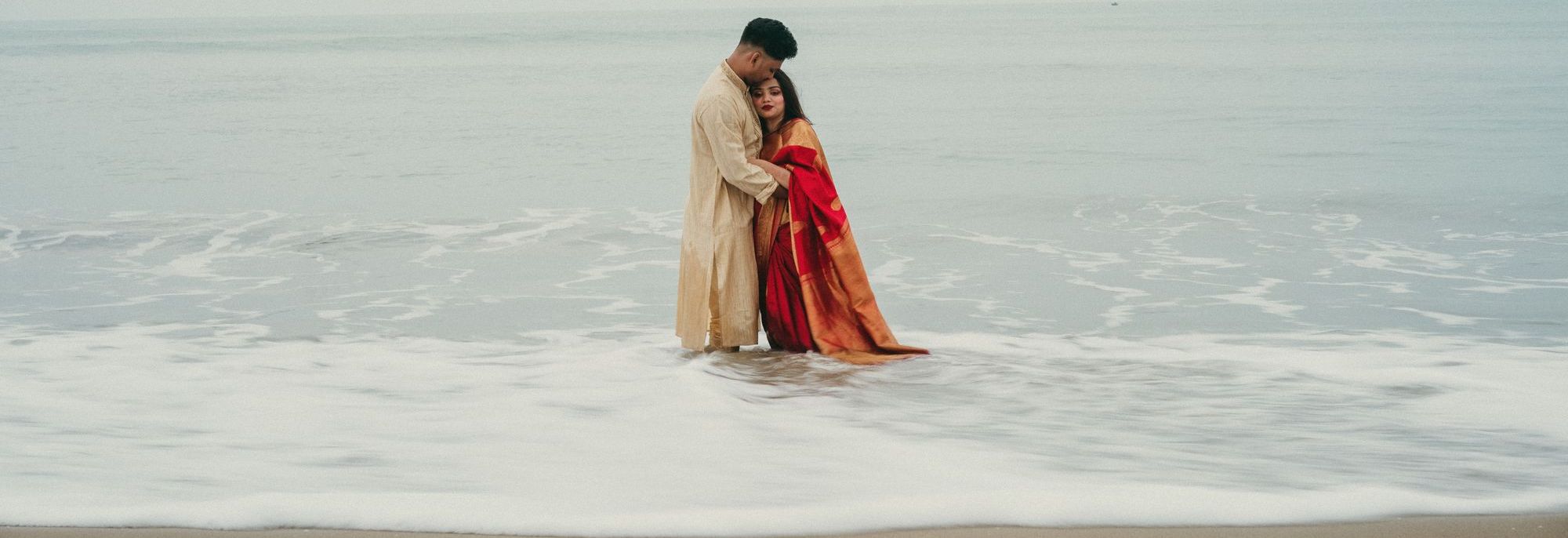 A couple embracing at the edge of the sea